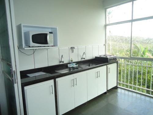 迪亚曼蒂纳Hospedagem Solar do Rosário的白色的厨房配有水槽和微波炉