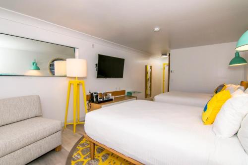 圣地亚哥海洋公园旅馆的客房设有两张床、一张沙发和一台电视。