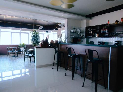 洞海Hoang Dat Hotel的餐厅的酒吧,有凳子