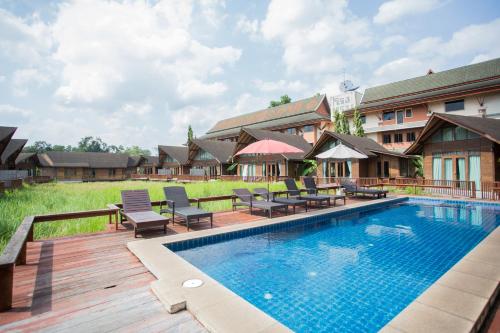素叻100 Islands Resort & Spa的一个带桌椅的度假村游泳池