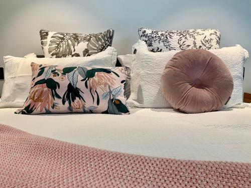 纳皮尔SEAduction Luxury Apartment的一张带白色枕头和粉色毯子的床