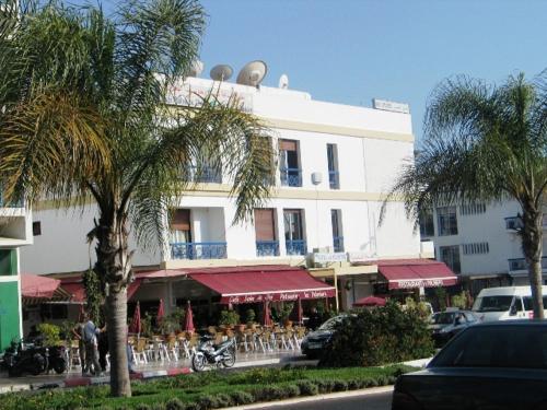 阿加迪尔Hotel les palmiers的一座白色的大建筑,前面有棕榈树