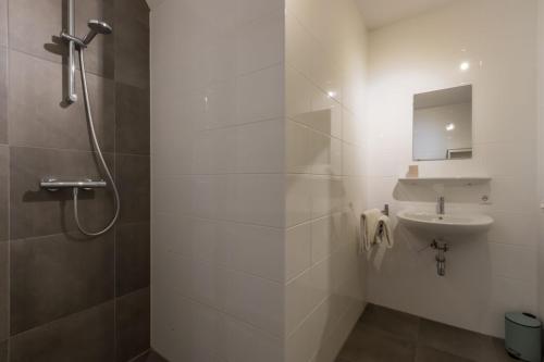 柯德科克Appartement - Kaapduinseweg 13 Dishoek M Luxe 6 personen的带淋浴和盥洗盆的白色浴室