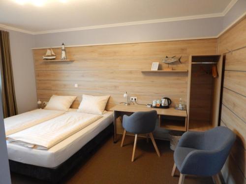 格罗森克内滕Hotel garni Haaster Krug Otte的酒店客房带一张床、一张桌子和椅子