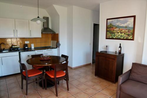 拉克鲁斯Hapimag Ferienwohnungen Puerto de la Cruz的厨房以及带桌椅的用餐室。