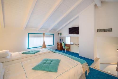 皮佐短笛大酒店的卧室配有带绿色枕头的大型白色床