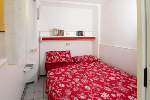 卡瓦利诺Camping Village Miramare的一间小卧室,房间内设有一张红色的床