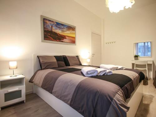 那不勒斯ChilometroZERO luxury apartment的一间卧室配有一张大床和两条毛巾