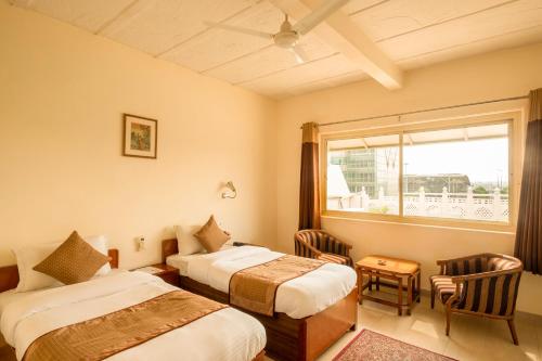 新德里空港酒店的酒店客房设有两张床和窗户。