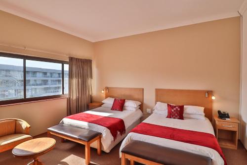 勾讷比Gonubie Hotel的酒店客房设有两张床和窗户。