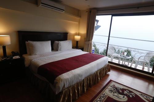 穆里Hotel One Bhurban的一间带大床的卧室和一个阳台