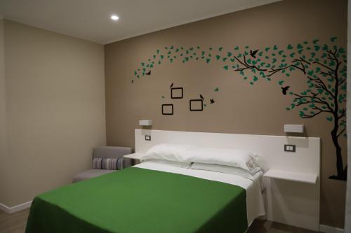雷焦卡拉布里亚Tre Fontane的卧室配有一张床,墙上有一棵树