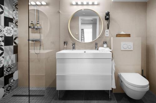 布达佩斯Jobelhome Apartments的一间带水槽、卫生间和镜子的浴室