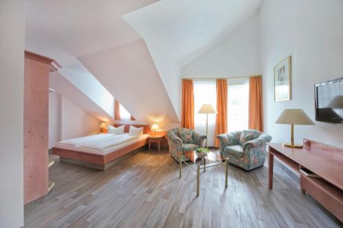 米特威茨巴赫雷因沃德酒店的酒店客房配有一张床、一张沙发和椅子。