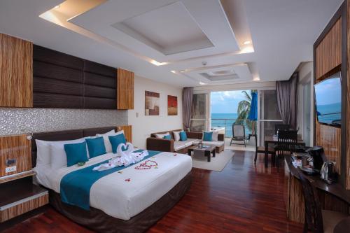 拉迈Royal Beach Boutique Resort & Spa Koh Samui - SHA Extra Plus的一间带大床的卧室和一间客厅
