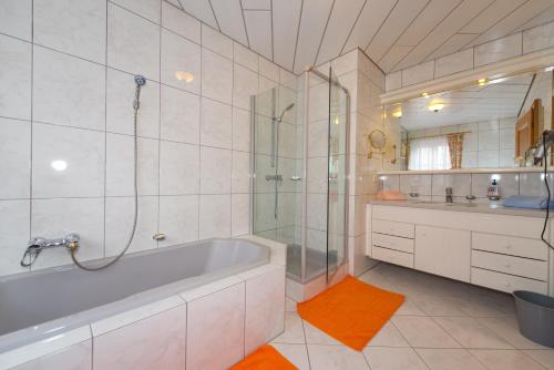 瓦格赖恩菲林豪斯曾特拉尔旅馆的带浴缸、淋浴和盥洗盆的浴室