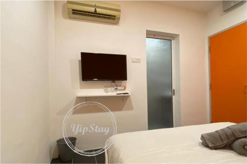 务边YipStay的卧室配有一张床,墙上配有电视。
