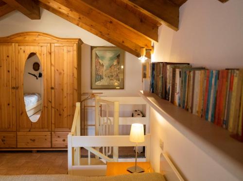 MiazzinaCORTE DI CAVNE'的一间设有楼梯的房间,并提供一些书籍