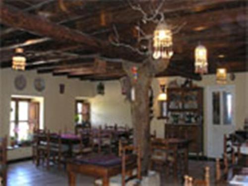 La TudaLos Jerónimos的配有桌椅和木制天花板的客房