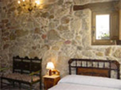 La TudaLos Jerónimos的一间卧室设有一张床和石墙