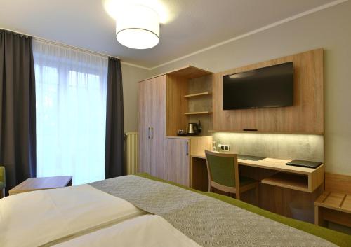Emstek瓦德舒餐厅酒店的酒店客房配有一张床、一张书桌和一台电视。