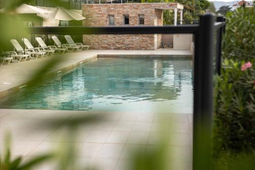 滨海萨纳里Soleil et Jardin的房屋内带椅子的游泳池