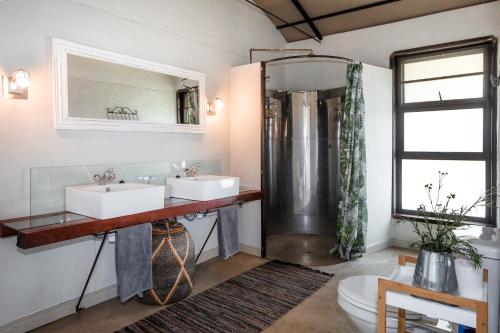 MbalastinteSerondela Lodge的一间带两个盥洗盆和淋浴的浴室