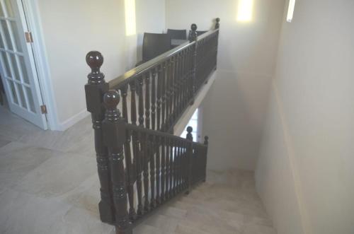 圣彼得教区Ixoras Beach Apartments的走廊上带有黑色栏杆的楼梯