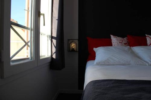 贝利罗曼维利而DISNEYLAND PARIS NEW STUDIO SUITE DESIGN的靠窗的一张带红白色枕头的床