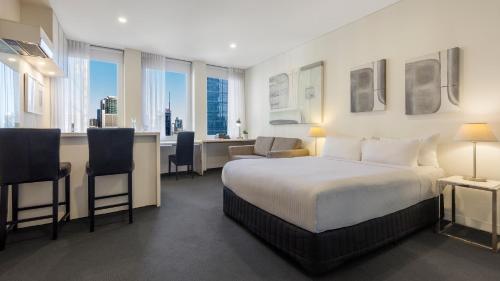 墨尔本Oaks Melbourne on Collins Suites的配有一张床和一张书桌的酒店客房