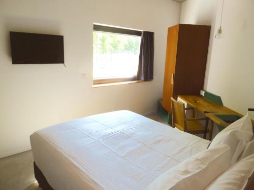 布鲁塞尔贝尔武酒店的一间卧室配有一张床、一张书桌和一个窗户。