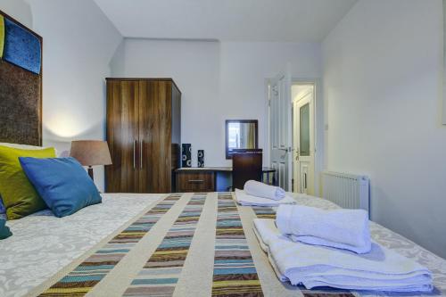 普雷斯蒂克Garden Gate Upper Apartment的一间卧室配有带毛巾的床