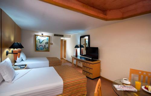 瓜达拉哈拉Hotel Guadalajara Plaza Ejecutivo的酒店客房设有两张床和电视。