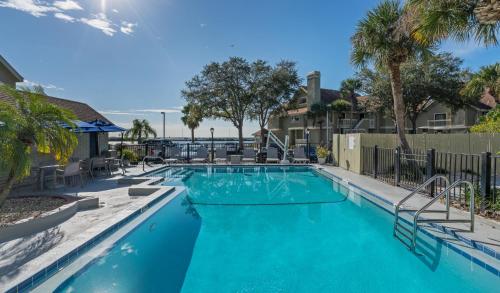 坦帕Chase Suite Hotel Rocky Point Tampa的一座拥有蓝色海水和棕榈树的大型游泳池