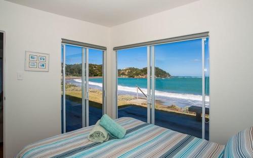 图图卡卡Shoreside - Tutukaka Holiday Home的一间卧室设有一张床,享有海景