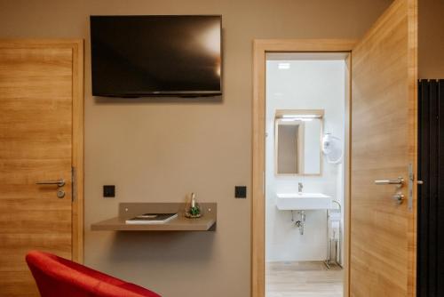 PetrovčeRooms VERDE的客房设有带水槽和红色椅子的浴室
