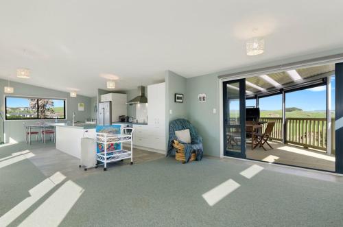 怀普The Blue Cottage with WiFi- Waipu Holiday Home的厨房和客厅,享有海景