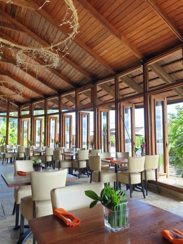 帕拉马里博Houttuyn Wellness River Resort的餐厅设有木制天花板和桌椅