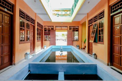 KemadangHotel Kukup Indah的一座室内游泳池,位于拥有橙色墙壁的房间