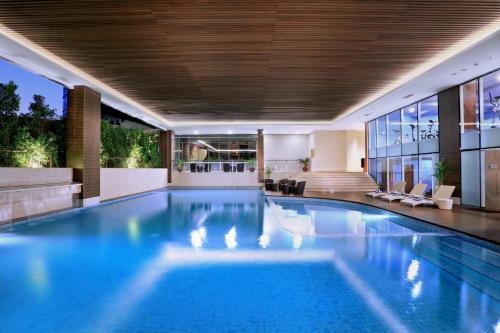 塞尔蓬加丁塞尔彭阿特里亚酒店的一座带房子的建筑里的一个大型游泳池
