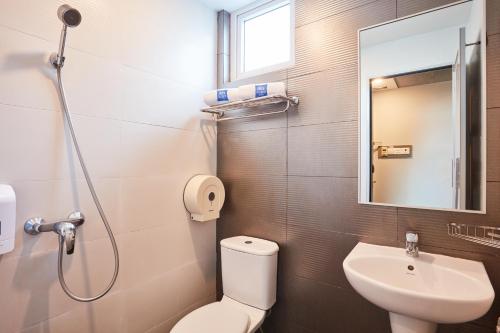 新加坡ibis budget Singapore Bugis的一间带卫生间、水槽和镜子的浴室