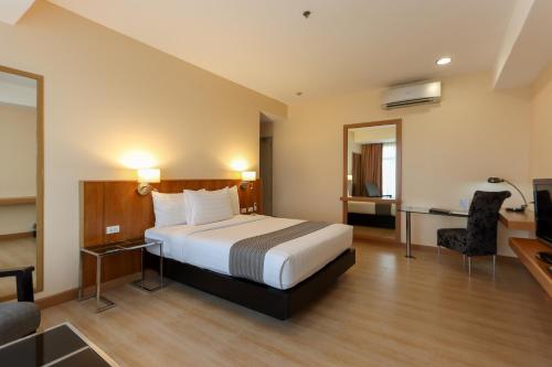 圣罗莎Paseo Premiere Hotel的配有一张床和一张书桌的酒店客房