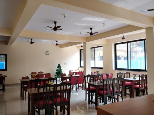 卡兰古特Dom's Inn的用餐室配有桌椅和圣诞树
