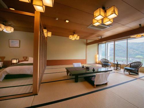 岩国市岩国市扣库赛䕋光酒店的一间卧室配有一张床、一张桌子、一张床和窗户。