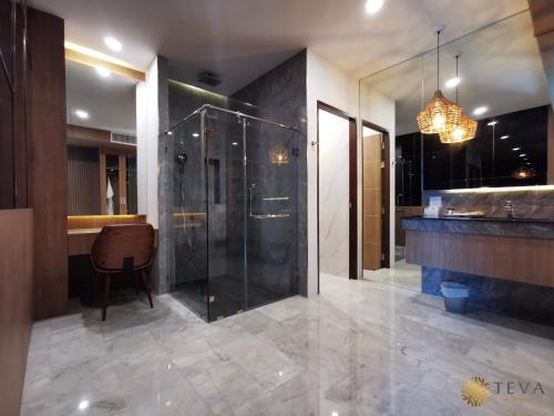 清莱TEVA Valley Resort的一间带玻璃淋浴和吊灯的浴室