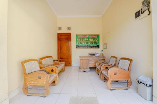 KemadangPenginapan Barokah的一间设有椅子和墙上标志的等候室
