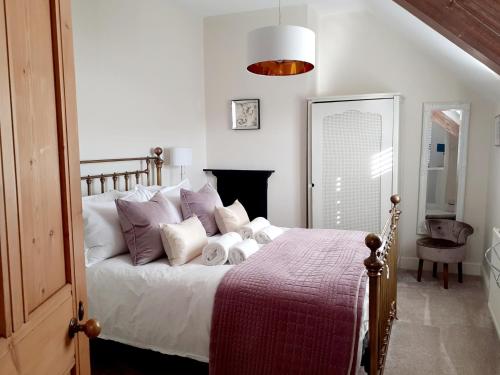 切斯特30 Overleigh Road的一间卧室配有一张带白色床单和紫色枕头的床
