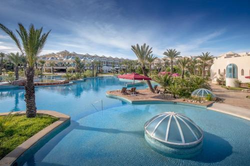 特里法Hasdrubal Prestige Thalassa & Spa Djerba的度假村内带船只的游泳池