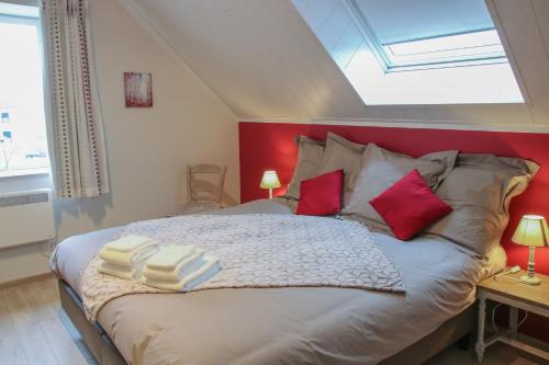 StaveLa petite maison dans la cour的一间卧室配有一张大床和红色床头板