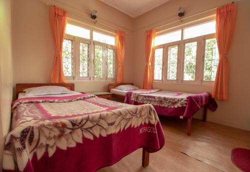 博卡拉新旅者旅馆的带窗户的客房内的两张床